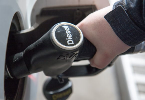 En som fyller diesel fra dieselpumpe.