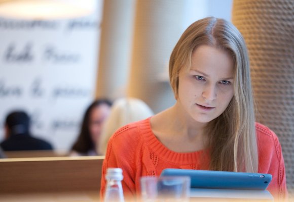 Student som sitter og jobber på et nettbrett.