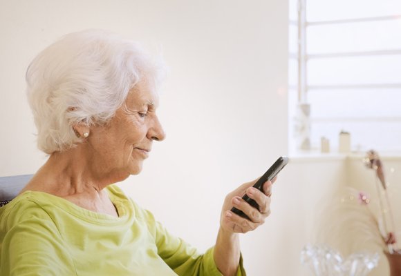 Eldre dame med mobiltelefon.