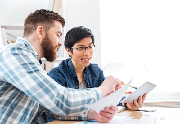 Kollegaer ser på arbeidstegninger og notater