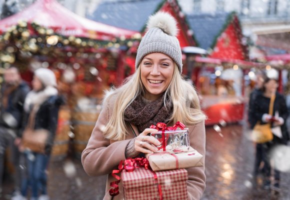 Dame som bærer på julegaver.