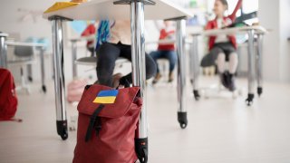 Ukrainsk jente på skolen, som sitter ved pulten sin og gjør lekser.