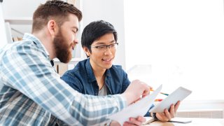 Kollegaer ser på arbeidstegninger og notater