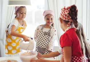 Fire jenter med forklær baker 