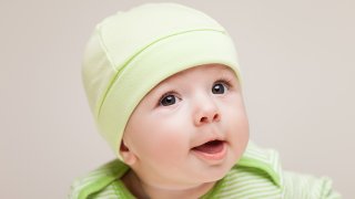 Nærbilde av baby med lysegrønn lue