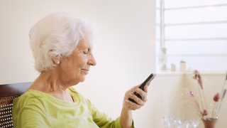 Eldre dame med mobiltelefon.