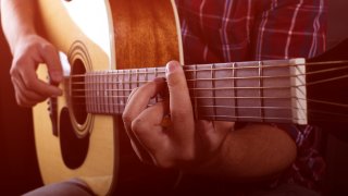 En mann som spiller gitar.