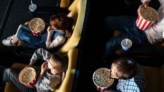 Gruppe med barn på kino som spiser popkorn