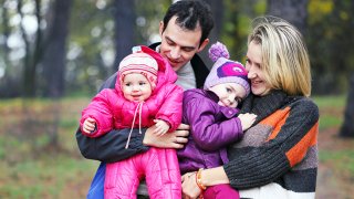 Familie på fire i park om høsten