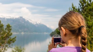 Illustrasjonsfoto av jente som fotograferer fjellet.