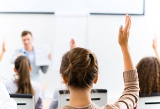 Personer som rekker opp hånda under undervisning.