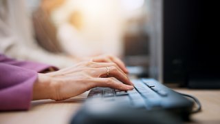 Hender som skriver på et PC-tastatur