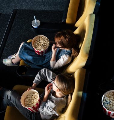Gruppe med barn på kino som spiser popkorn