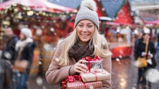 Dame som bærer på julegaver.