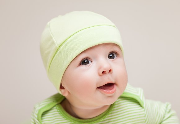 Nærbilde av baby med lysegrønn lue